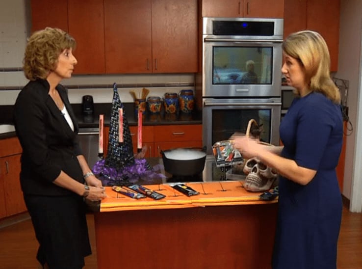 Julie Weber discusses Halloween safety items including glow sticks and face paint during a TV news segment