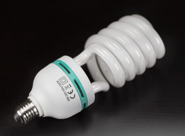 A CFL bulb (compact fluorescent bulb) on a black background.