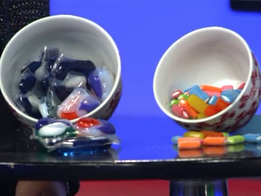 Two bowls side by side — one filled with colorful Tide laundry pods, the other filled with colorful candy — illustrating how similar the two can look.