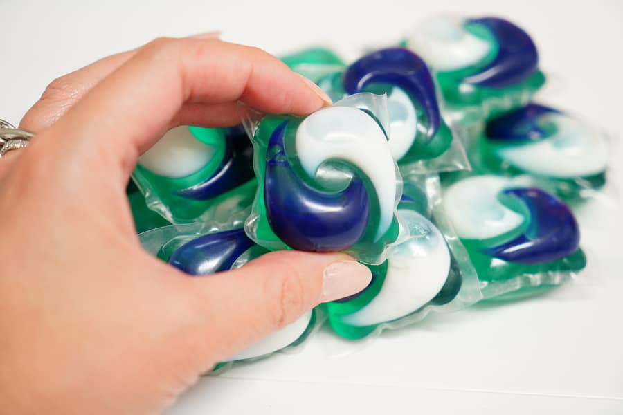 Someone's hand holding colorful laundry detergent pods.