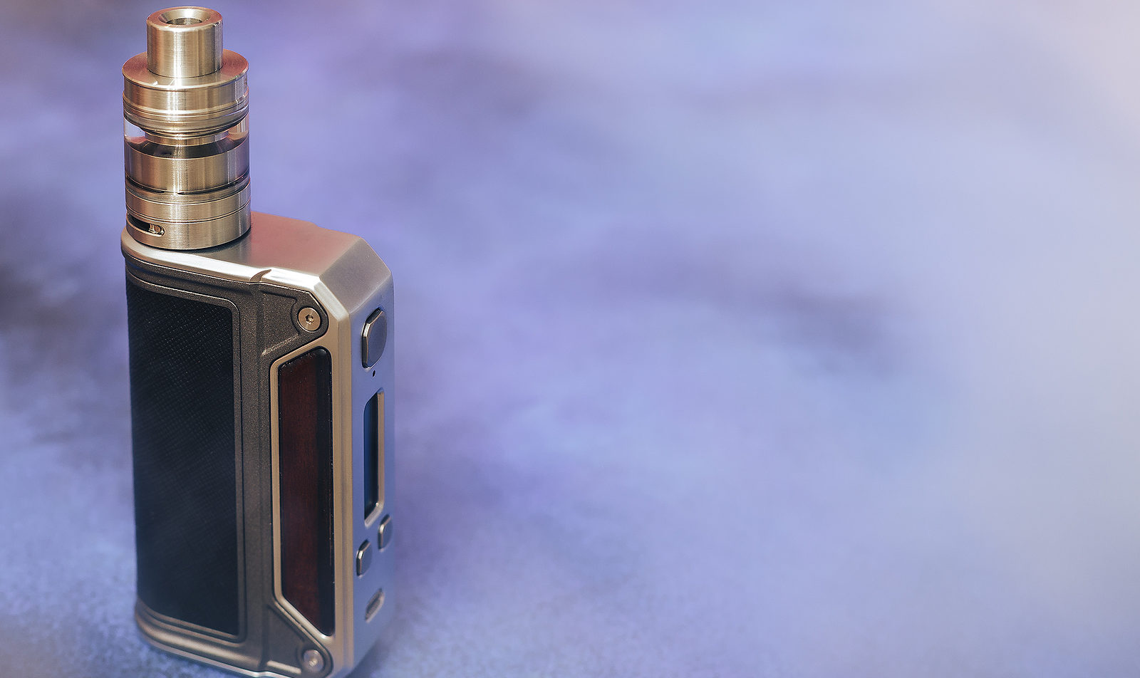 Close-up of a box mod vaping device surrounded by vapor