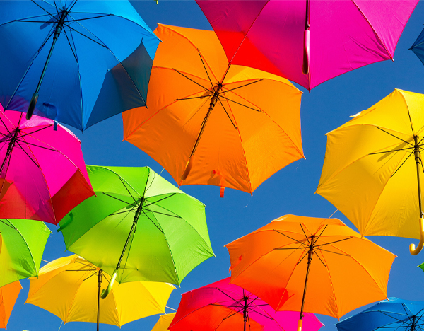 Colorful umbrellas floating against a bright blue sky