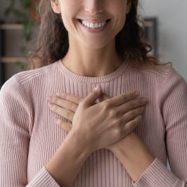 woman smiling with hands over her heart