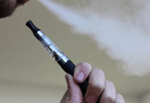 Hand holding a pen-style e-cigarette