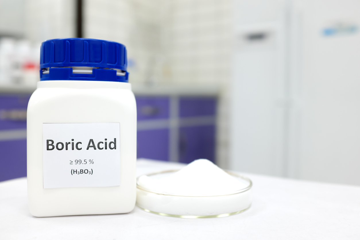 A canister of boric acid sits besides a small dish of boric acid cream on a doctors table.