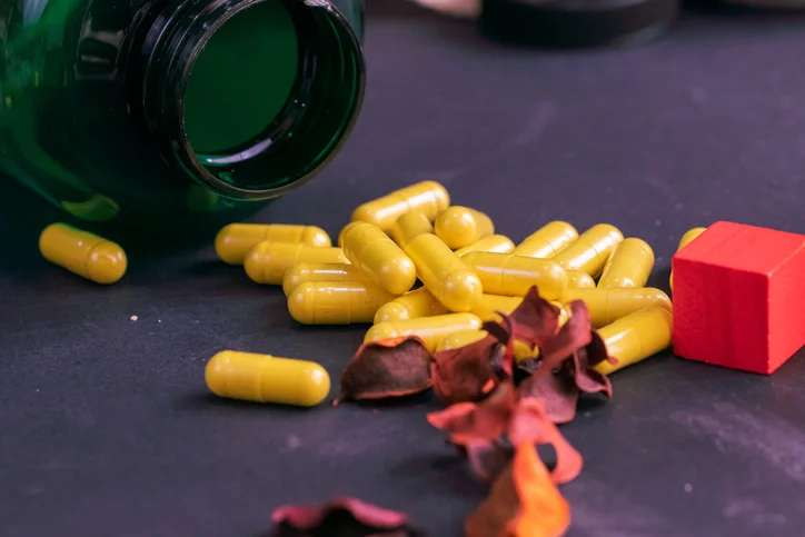 An overturned bottle of yellow berberine supplements.